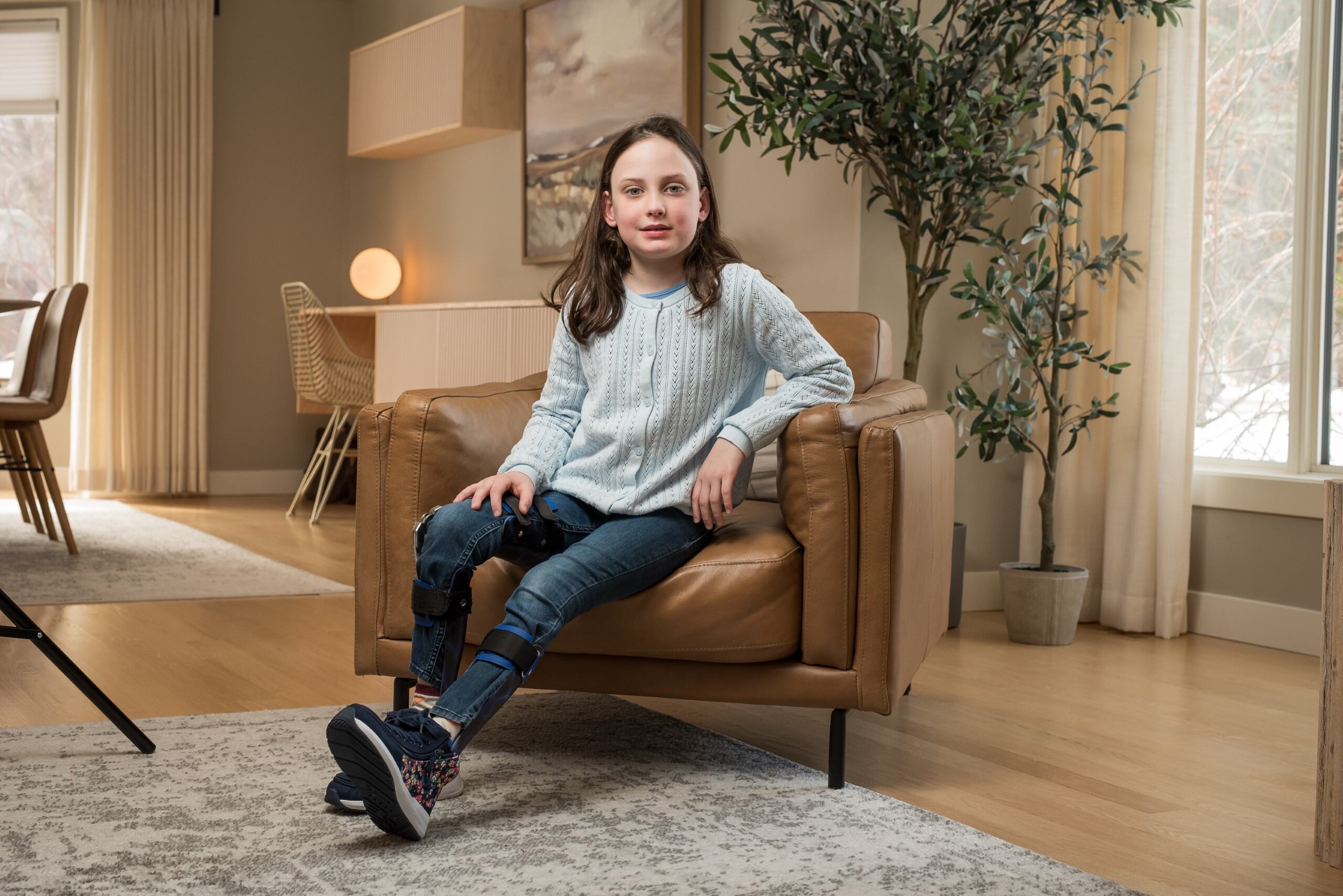 2025 CRF ambassador Claire poses in chair while wear her orthotics provided by CRF/RCC